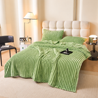 Green faux fur throw blanket spread over a bed in a sunlit bedroom