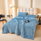 Blue faux fur throw blanket with raised stripes spread across a bed
