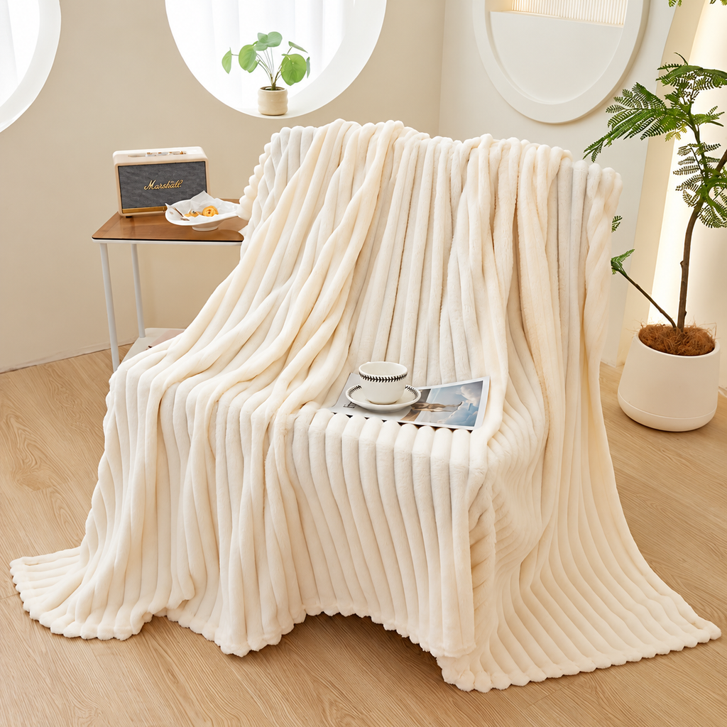 White faux fur throw blanket draped over a chair beside a plant and cup