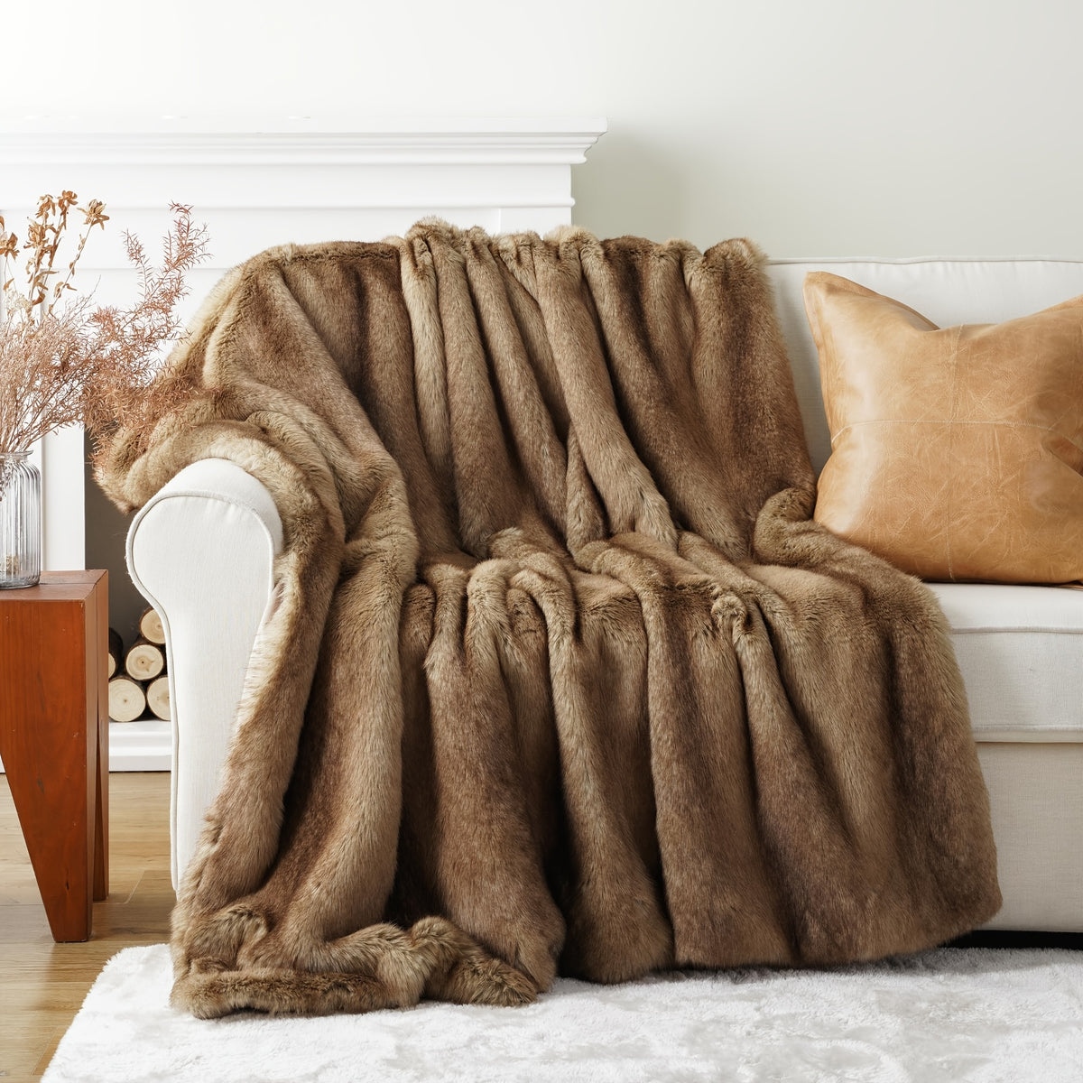 Tan faux fur throw blanket draped over a white chair.