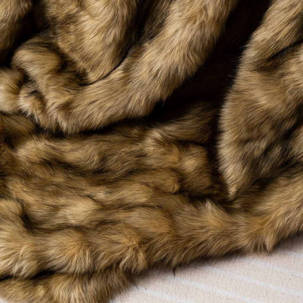 Close view of long brown pile on a faux fur throw blanket.