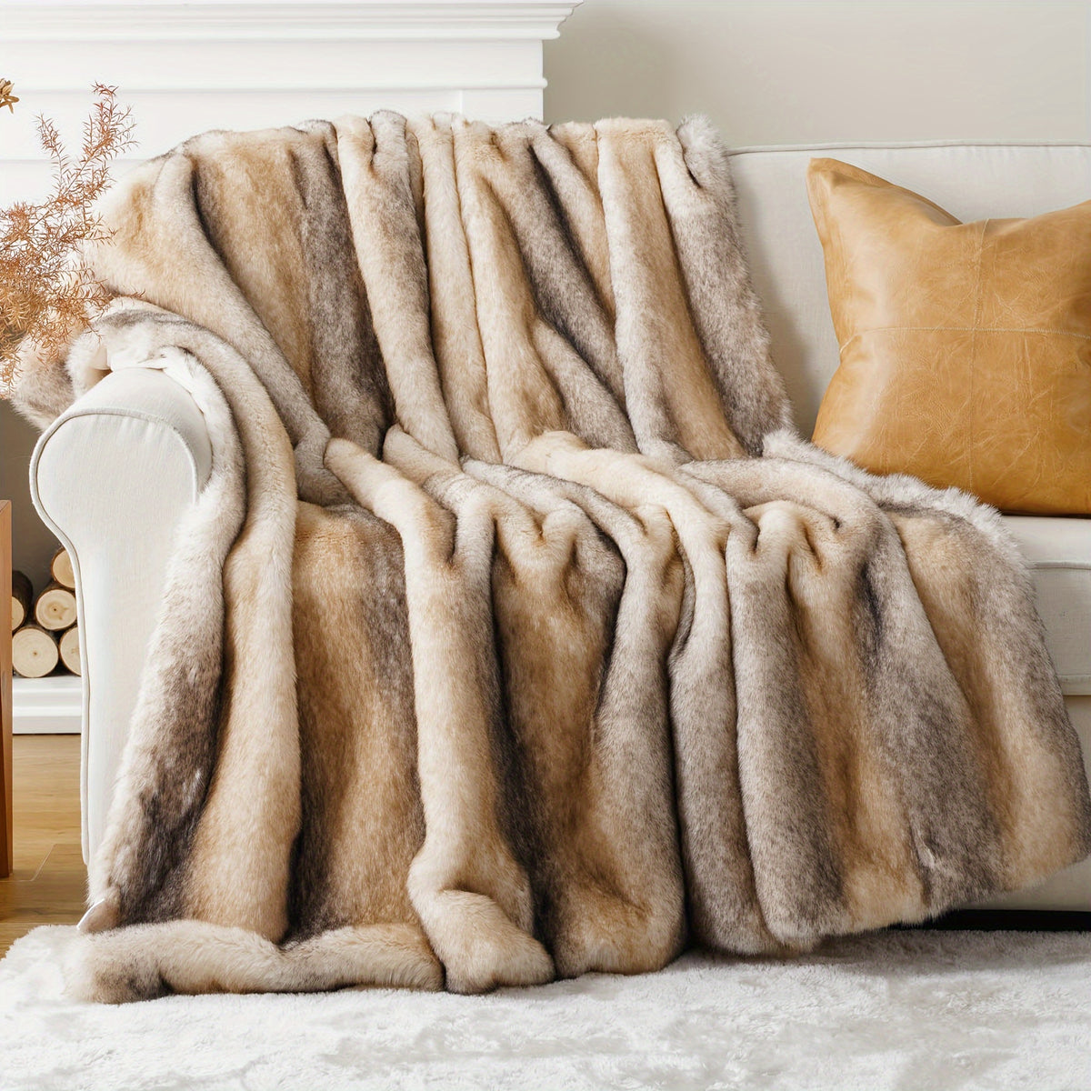 Cream and gray faux fur throw blanket over a white chair beside a tan pillow.