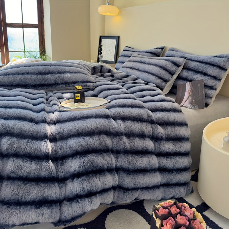 Blue gray faux fur throw blanket draped across a bed.