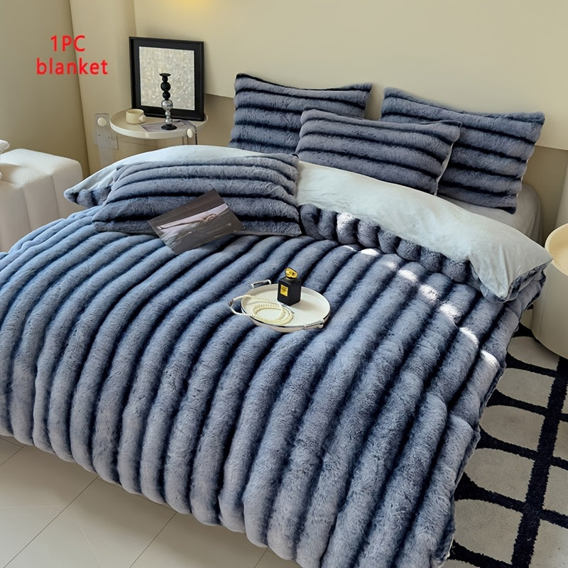 Blue faux fur throw blanket on a bed with a single blanket label.