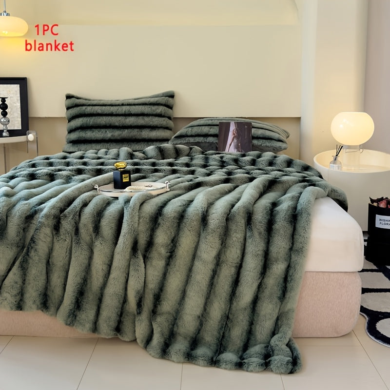 Green faux fur throw blanket draped across a bed.