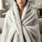 Woman wrapped in a white tipped long pile faux fur blanket.