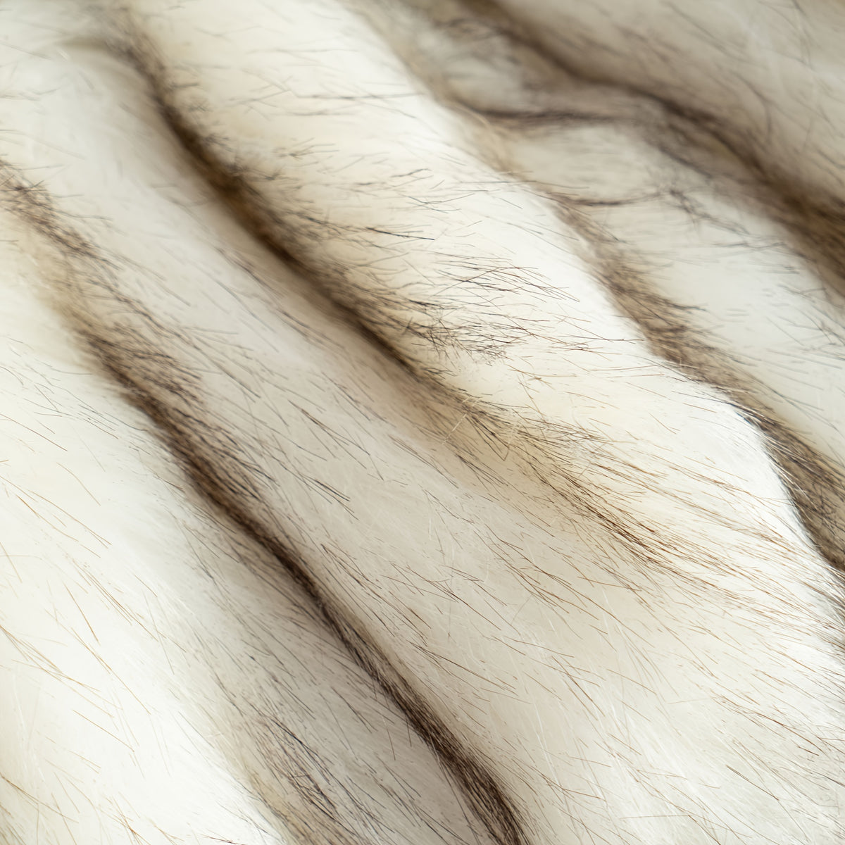 Close view of white and brown tipped faux fur fibers.