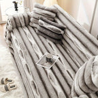 Close view of gray ribbed sofa cover folds and a phone on the seat.