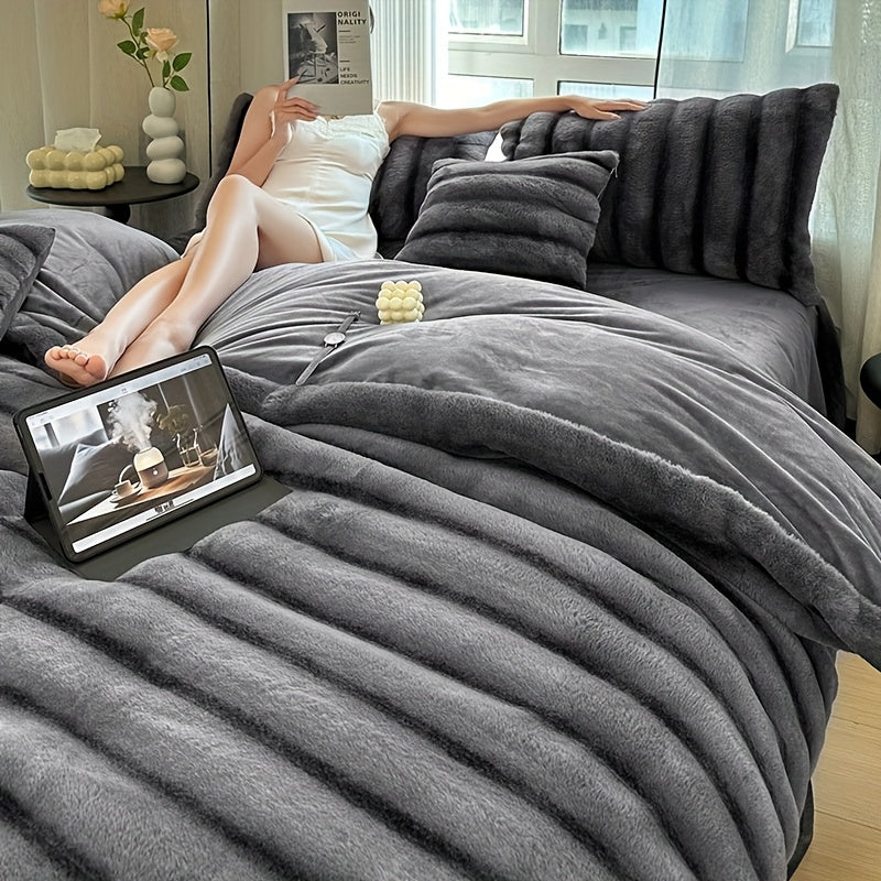 Woman resting on a couch under a gray ribbed faux fur blanket.