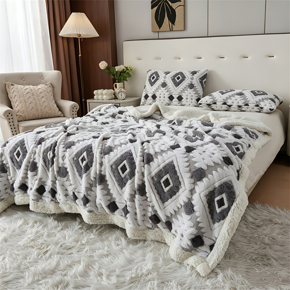 Gray and white diamond patterned faux fur blanket spread across a bed.