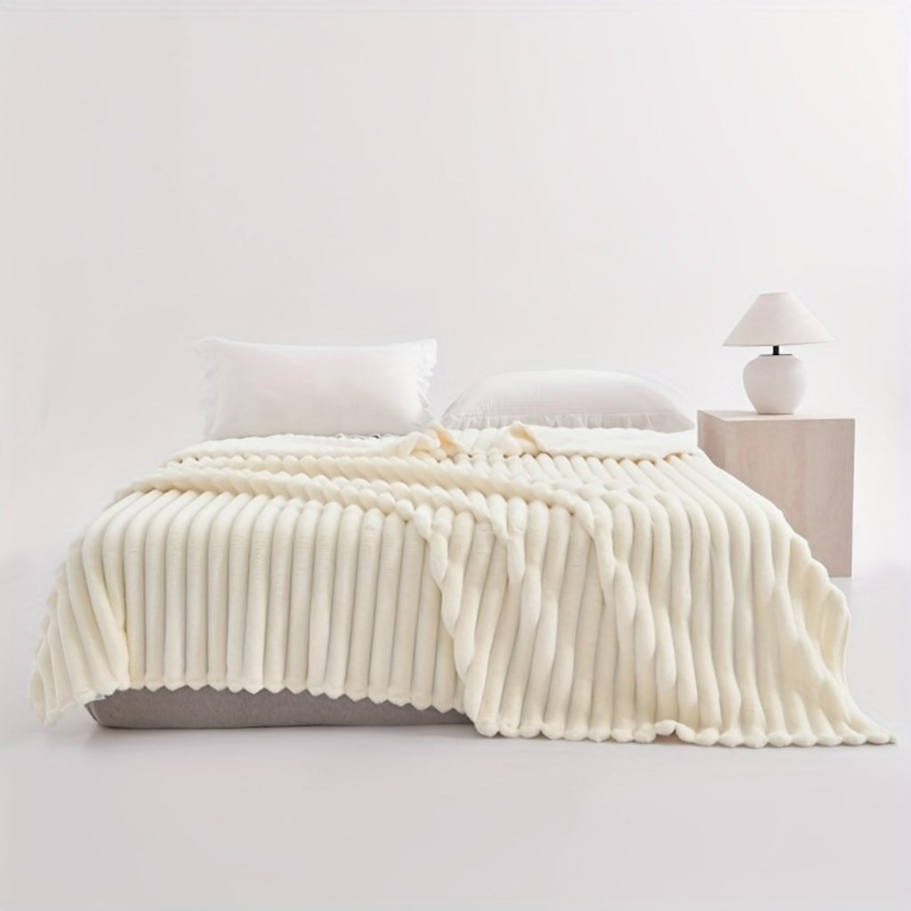 White ribbed faux fur blanket spread across a bed.