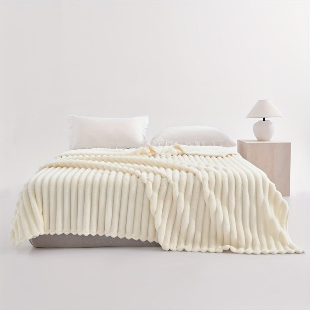 White ribbed faux fur blanket spread across a bed.