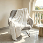 White ribbed faux fur blanket draped over a gray chair.
