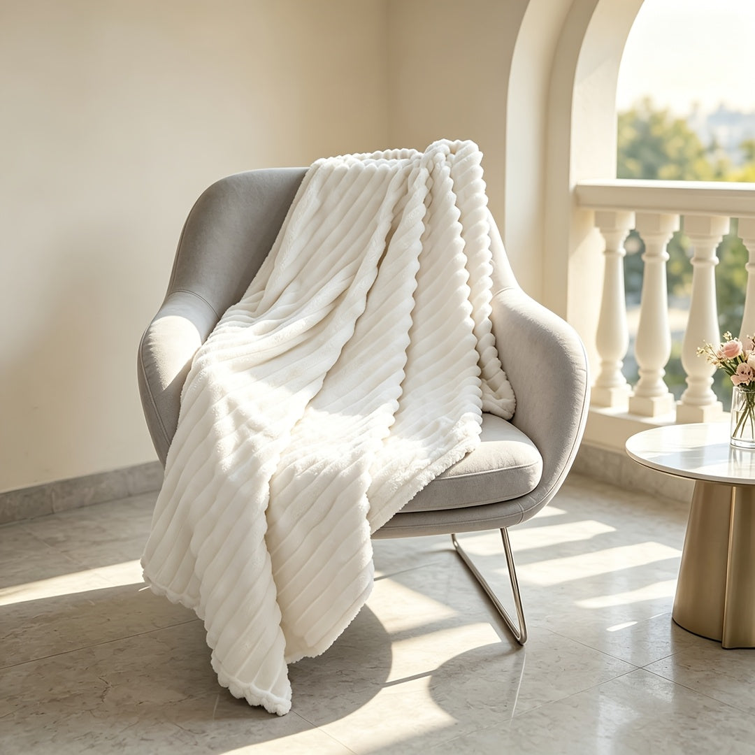 White ribbed faux fur blanket draped over a gray chair.
