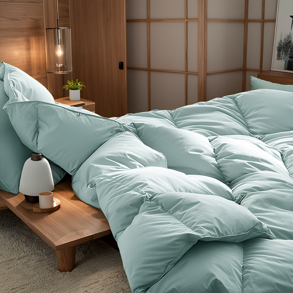 Light green duvet draped over a bed showing its smooth surface