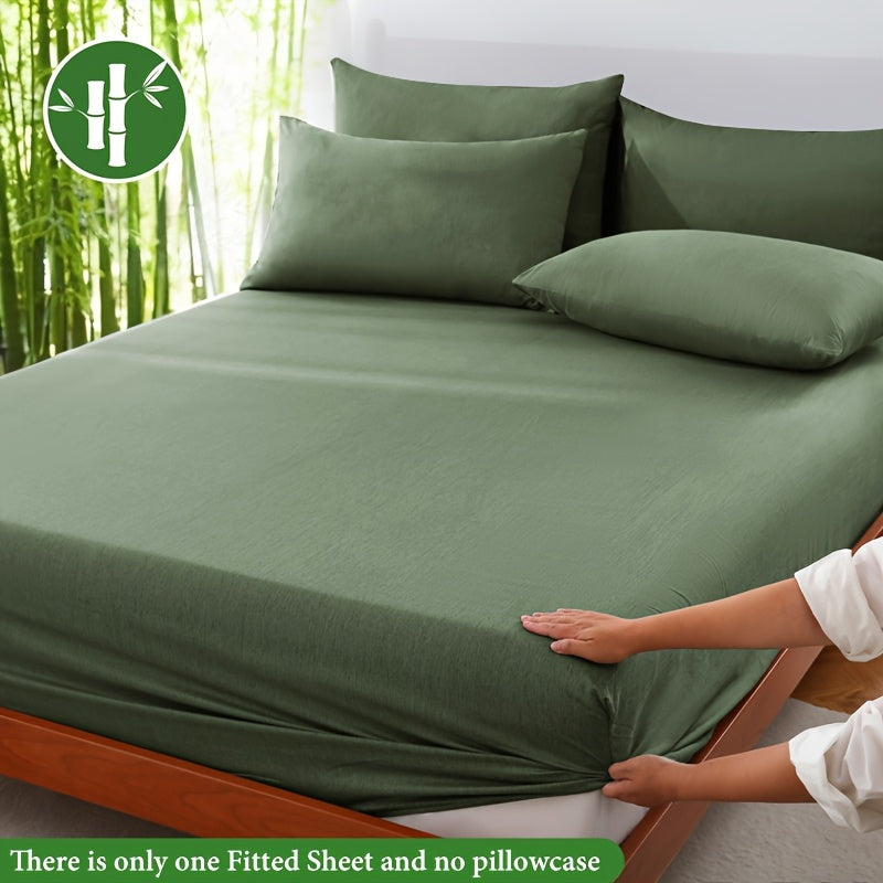 Olive green fitted sheet displayed on a bed with a bamboo graphic