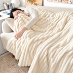 White ribbed flannel throw blanket covering a resting woman on a sofa