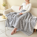Light gray ribbed flannel throw blanket across a seated person's lap