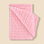 Folded pink fleece throw blanket showing the raised pattern and reverse fabric