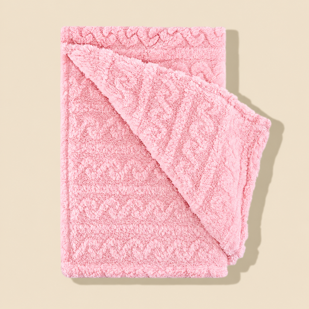 Folded pink fleece throw blanket showing the raised pattern and reverse fabric