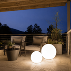 White rechargeable floating globe light glowing beside a modern pool