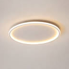 Circular flush mount ceiling light shown close up with a soft warm halo around the outer ring.