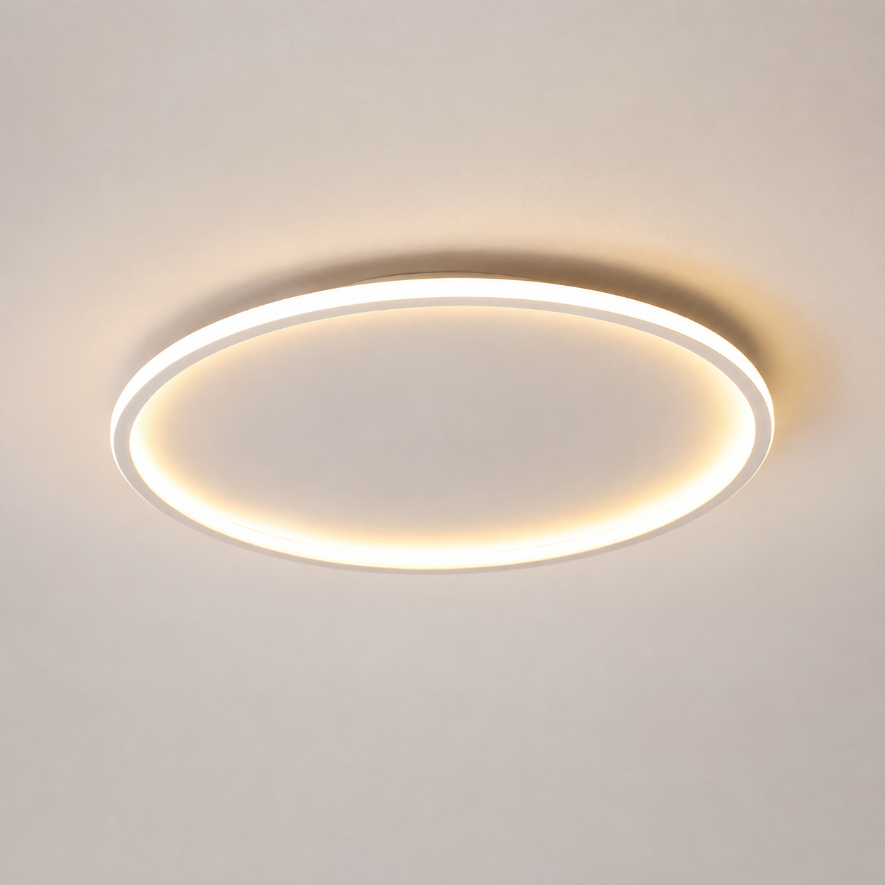 Circular flush mount ceiling light shown close up with a soft warm halo around the outer ring.