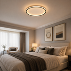 Circular flush mount ceiling light casting warm light above a neutral bedroom.