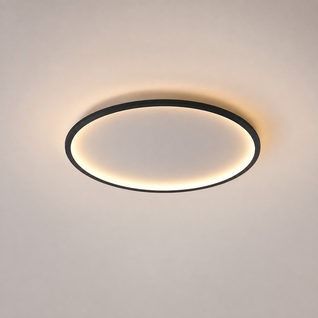 Circular flush mount ceiling light with a black rim and warm glowing ring on a neutral ceiling.