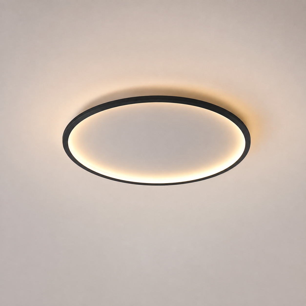 Circular flush mount ceiling light with a black rim and warm glowing ring on a neutral ceiling.