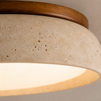 Macro view of the flush mount ceiling light showing the wood rim, textured beige body, and glowing diffuser.