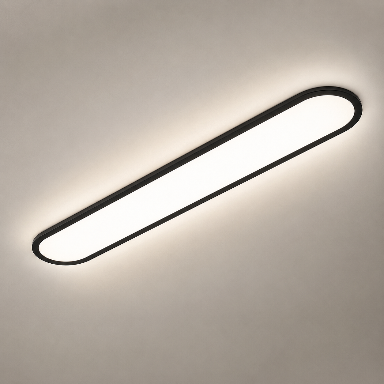 Black oval flush mount ceiling light glowing on a warm gray ceiling.