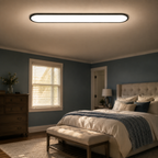 Flush mount ceiling light glowing above a dark bedroom with a large window.
