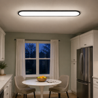 Flush mount ceiling light installed over a round dining table in a gray room.