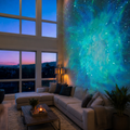 Black galaxy projector casting blue and purple nebula light across a bedroom