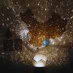Galaxy projector casting bright star patterns around two people in a dark room.