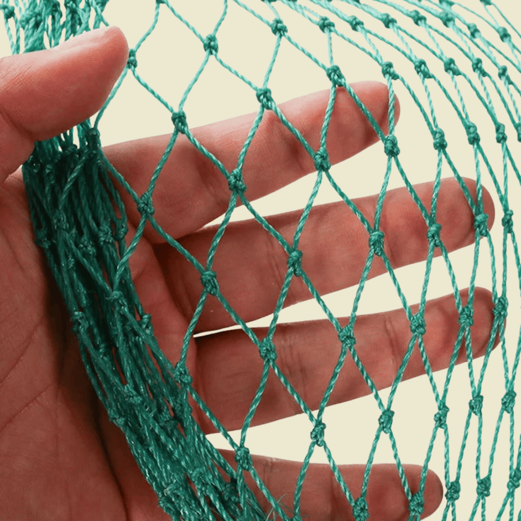 Close view of green two strand garden netting held against a hand