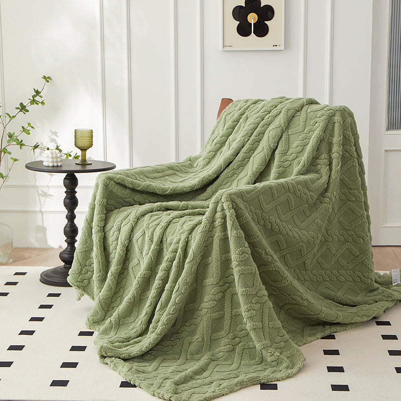 Green geometric fleece throw draped over an armchair