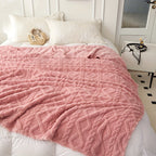 Pink geometric blanket spread across a bed