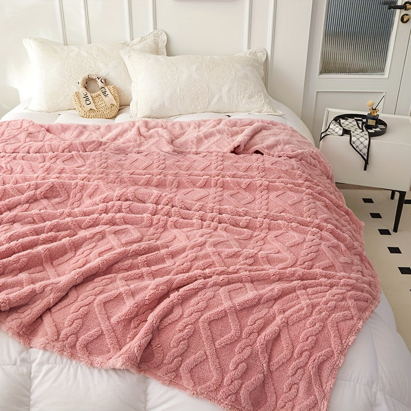 Pink geometric blanket spread across a bed
