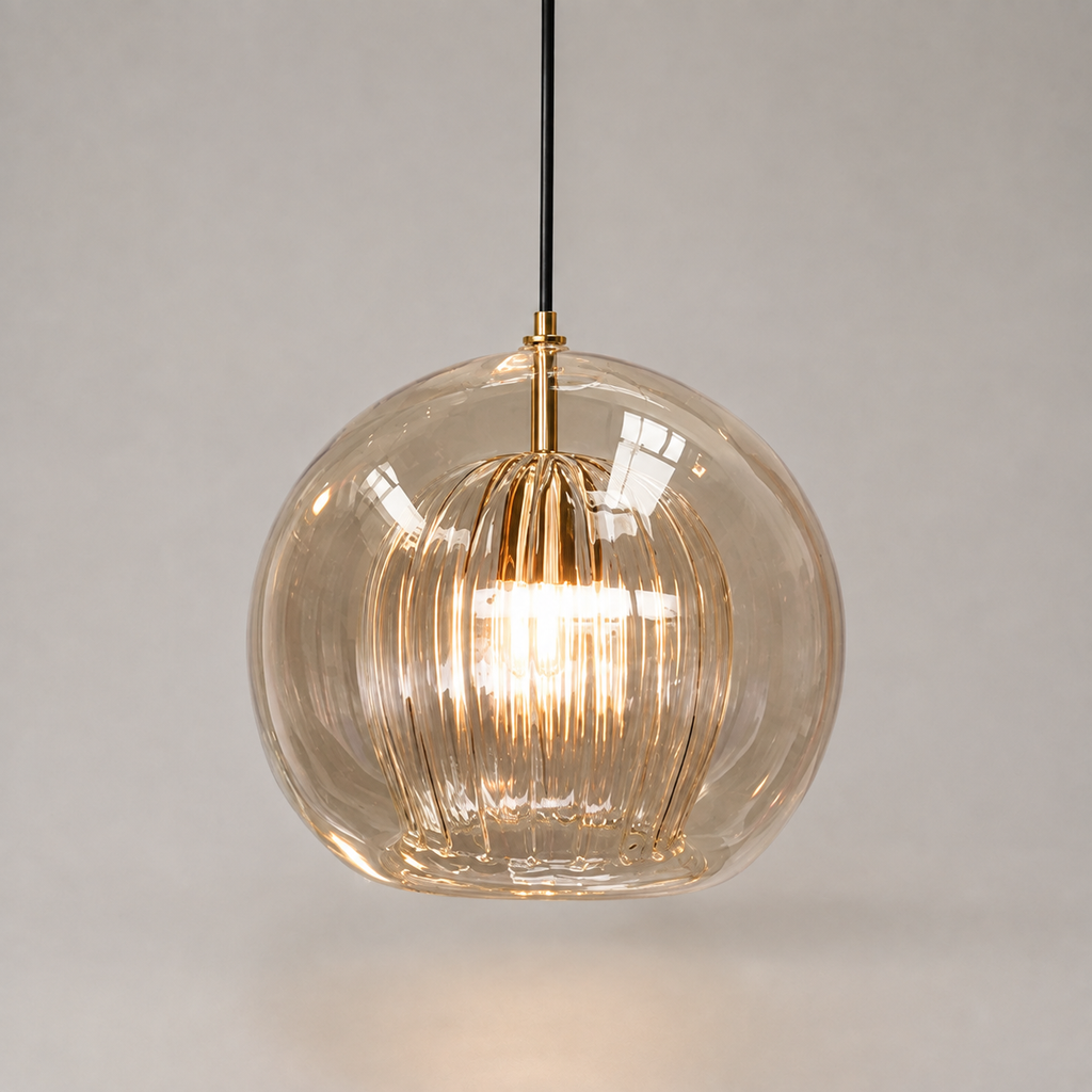 Amber ribbed glass pendant light with warm glow suspended against a soft beige studio background.