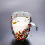 Floral double wall glass mug filled with a white beverage