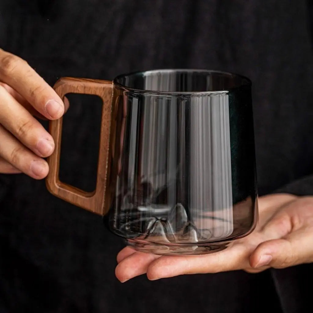 Empty smoky glass mug with sculpted mountain base and wooden handle