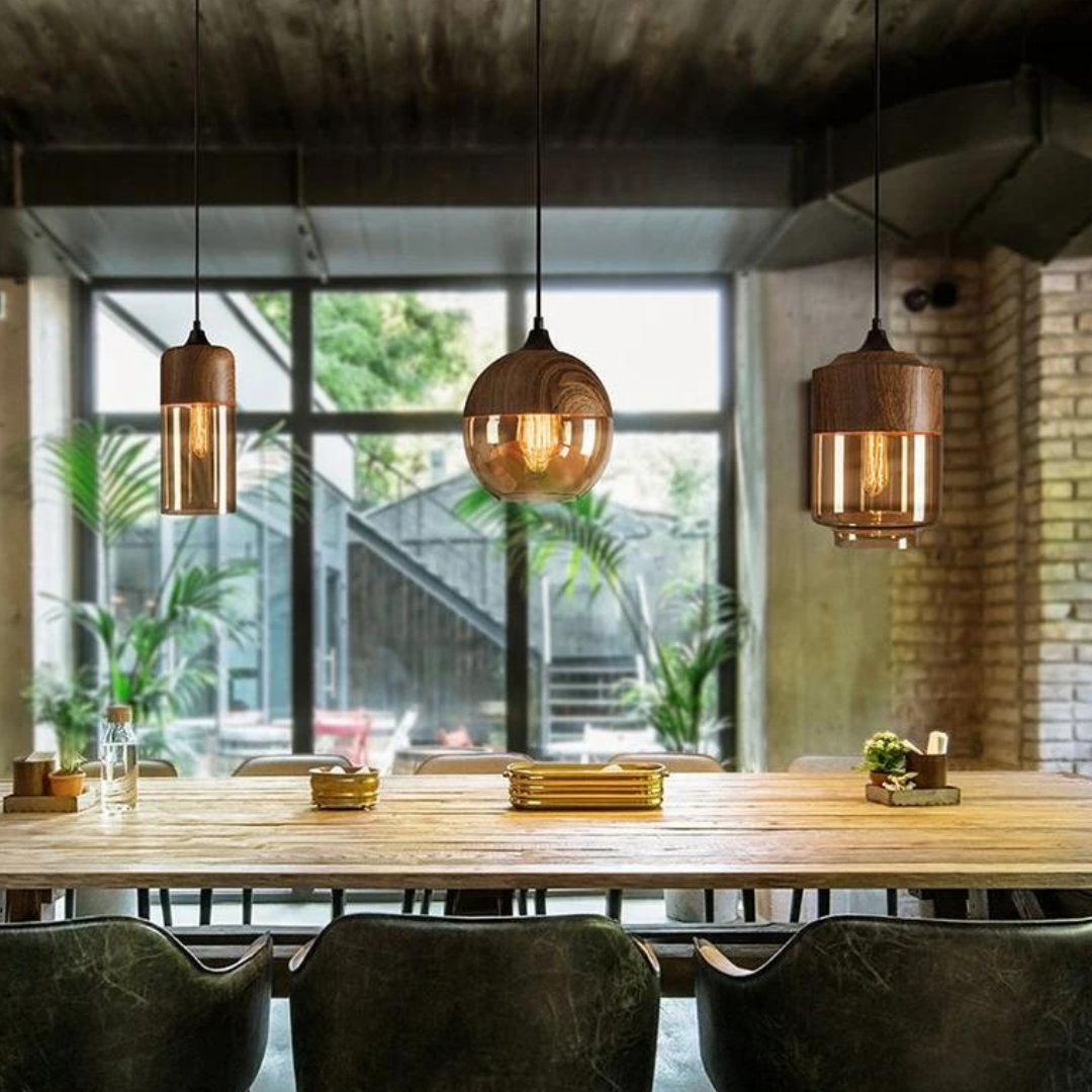 Glass pendant light arrangement over a table beside large windows