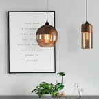 Glass pendant light pair displayed beside framed wall art