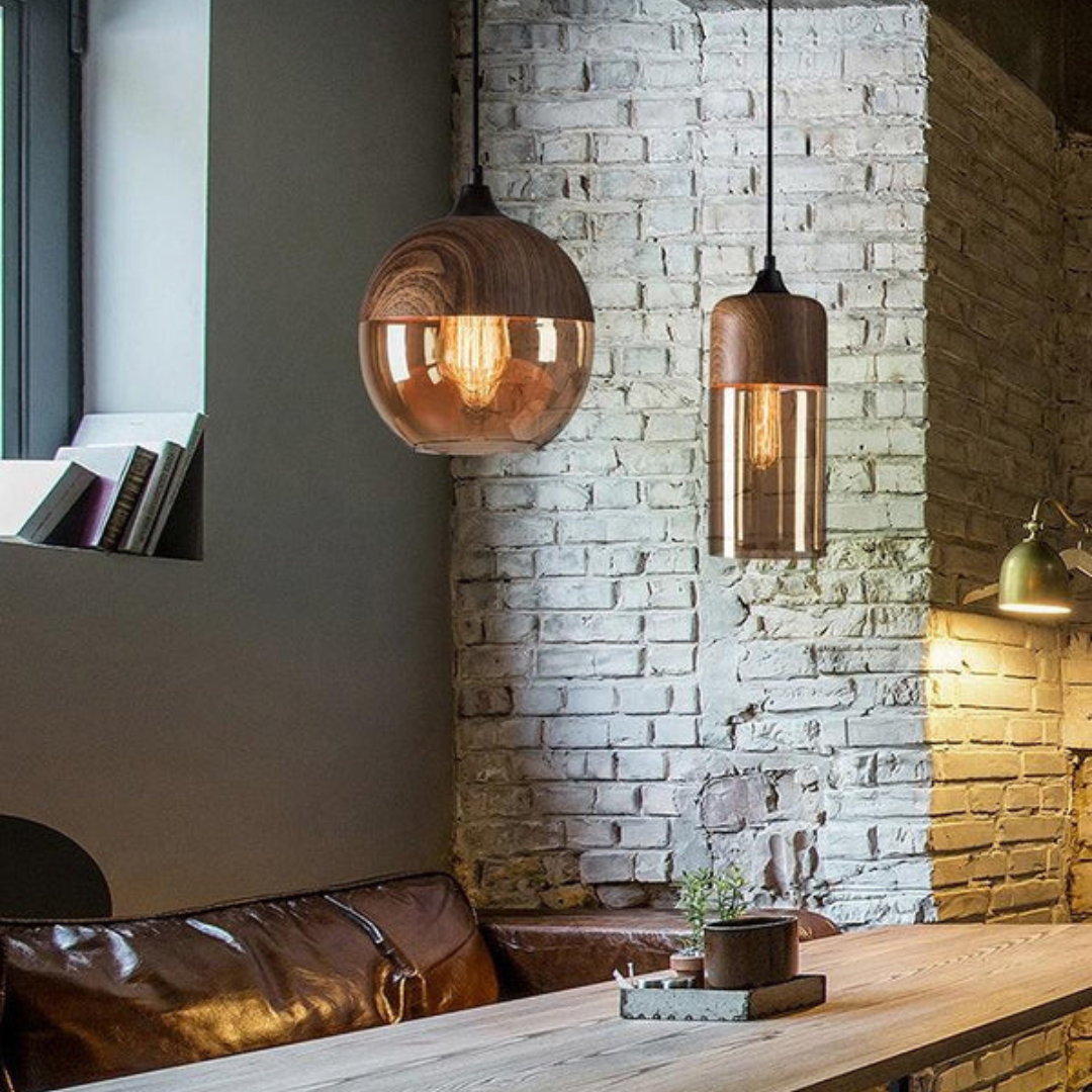 Glass pendant light pair hanging beside a brick wall