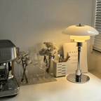 White glass table lamp with a silver finish beside a kitchen appliance