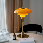 Amber glass table lamp with a gold finish on a dining table