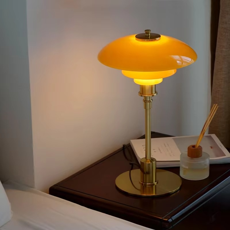 Amber glass table lamp with a gold finish on a side table