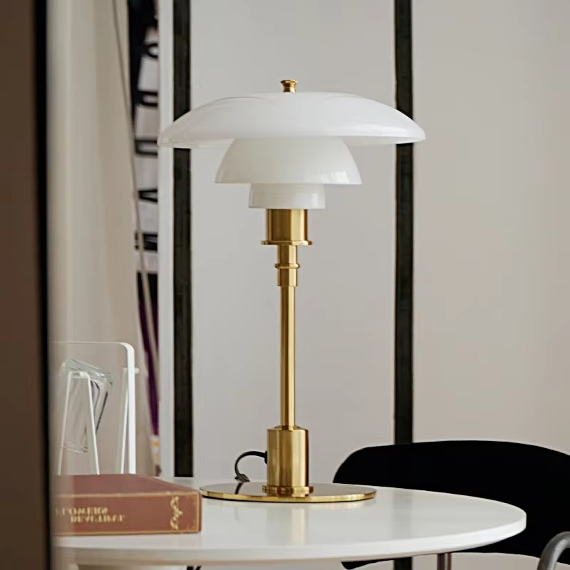 White glass table lamp with a gold finish on a round table